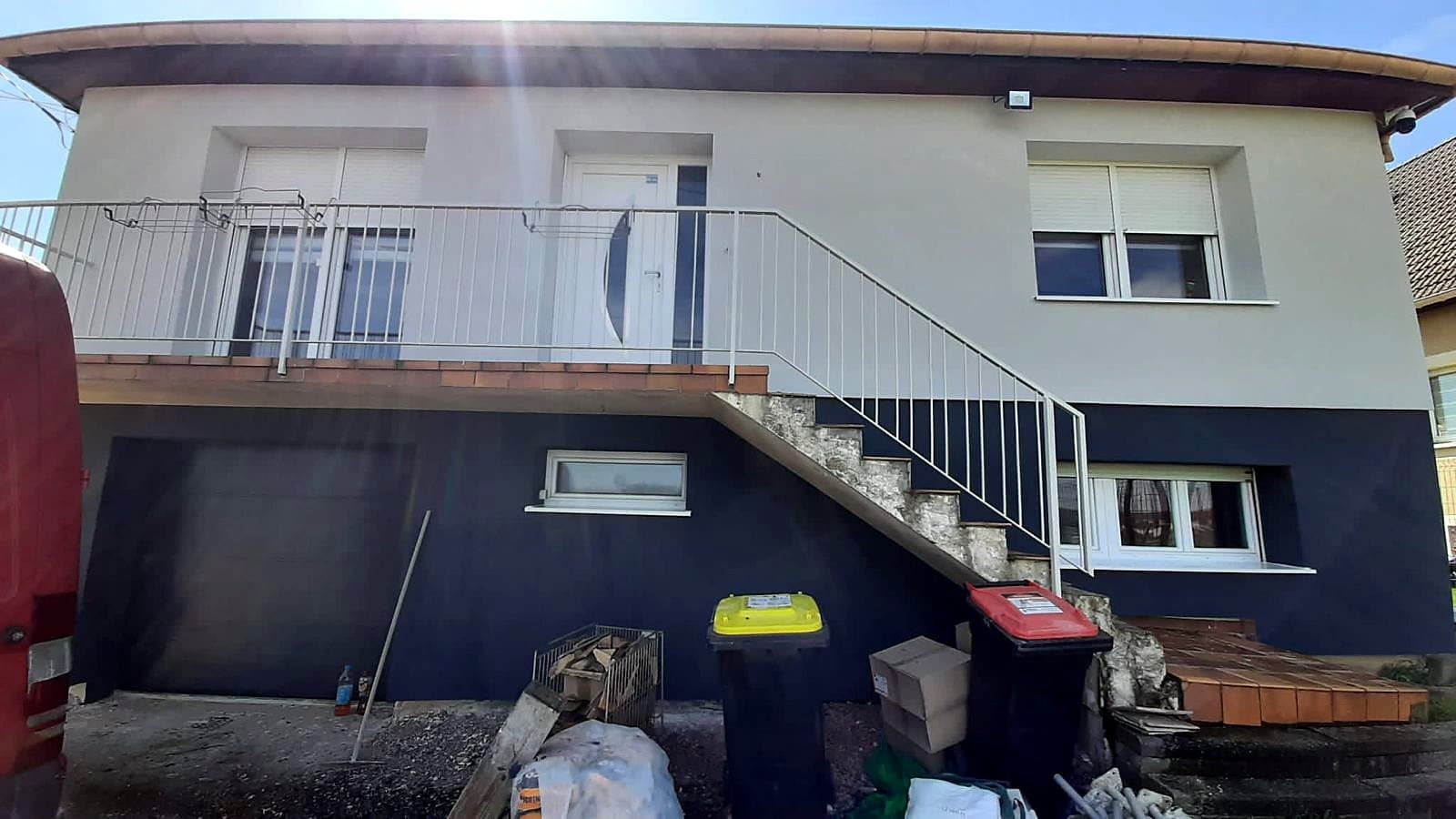 Après : La même maison après isolation par l'extérieur : enduit blanc à l'étage, soubassement bleu nuit