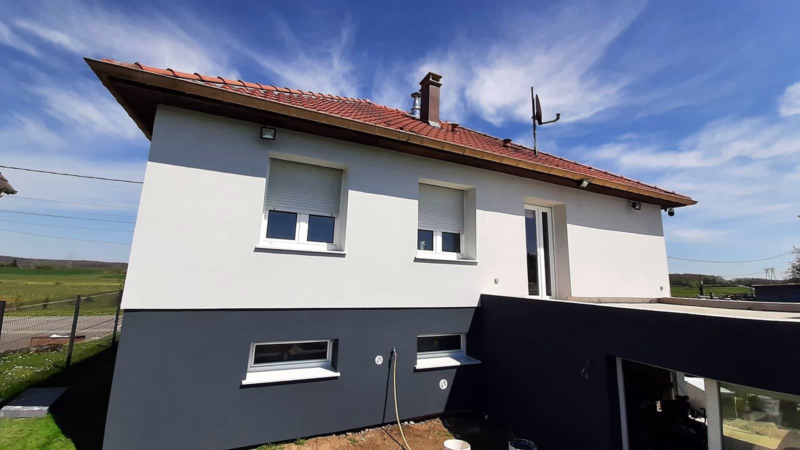 Après : La même maison après isolation par l'extérieur : enduit blanc, soubassement gris anthracite