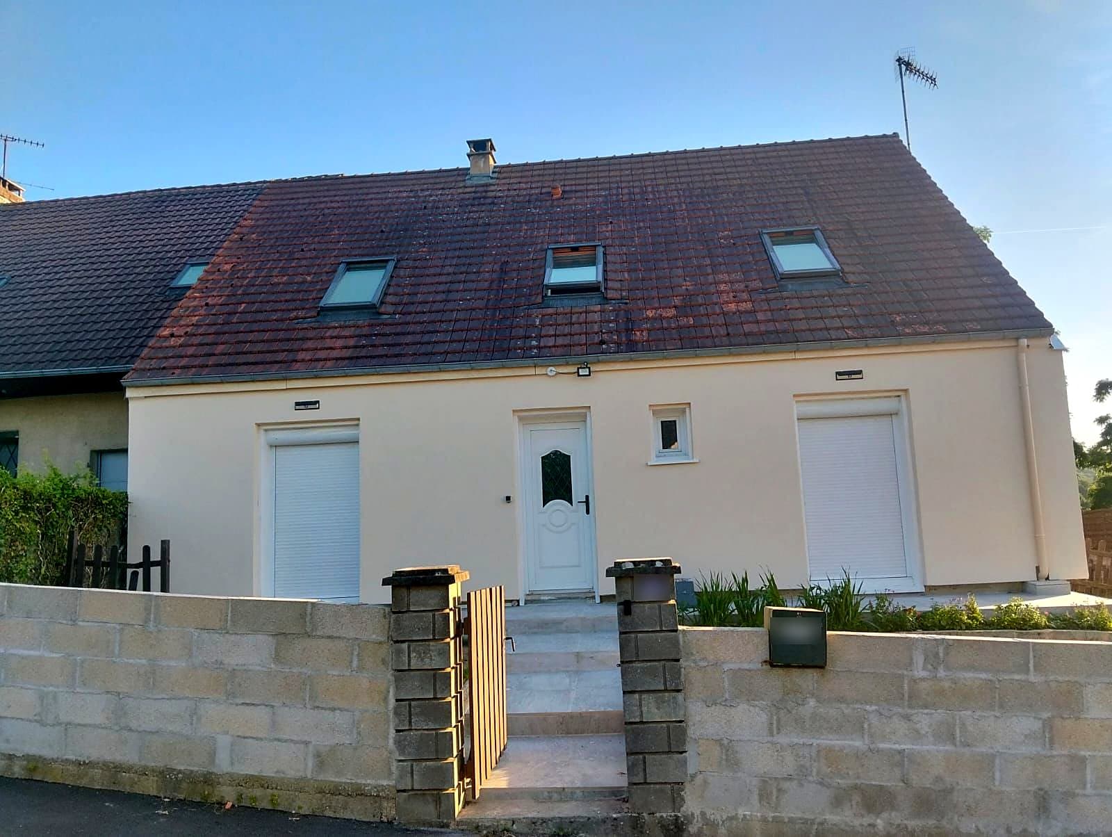 Maison mitoyenne après isolation par l'extérieur : enduit clair, volets roulants, fenêtres de toit