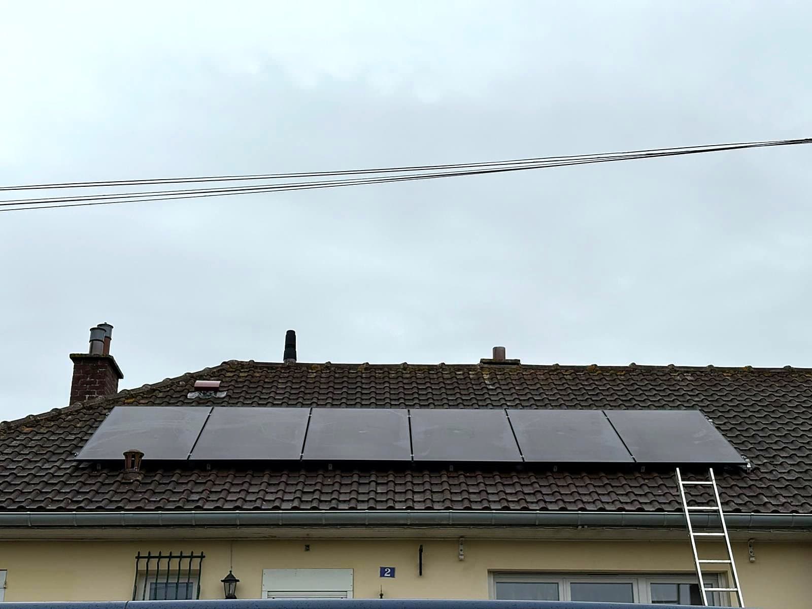 Panneaux photovoltaïques posés en une rangée sur une toiture en tuiles