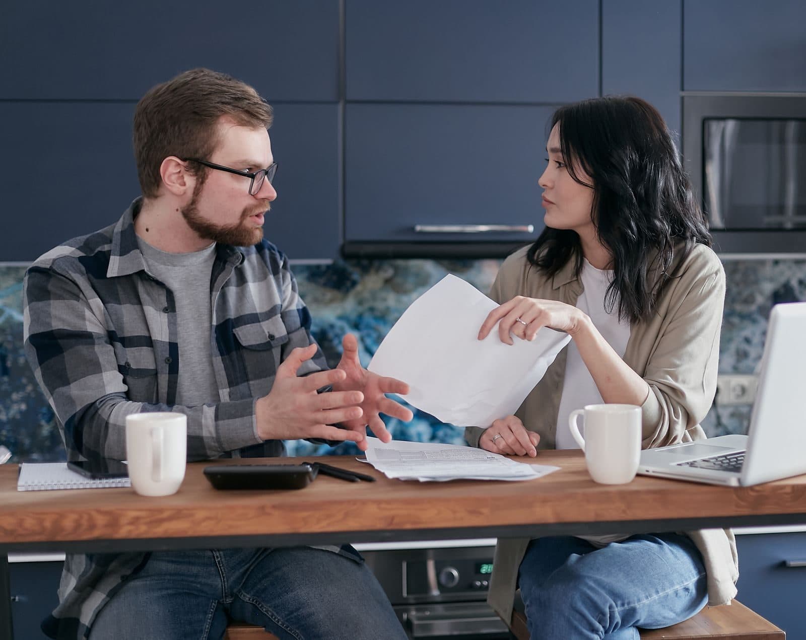 Couple qui étudie un document à la table de la cuisine